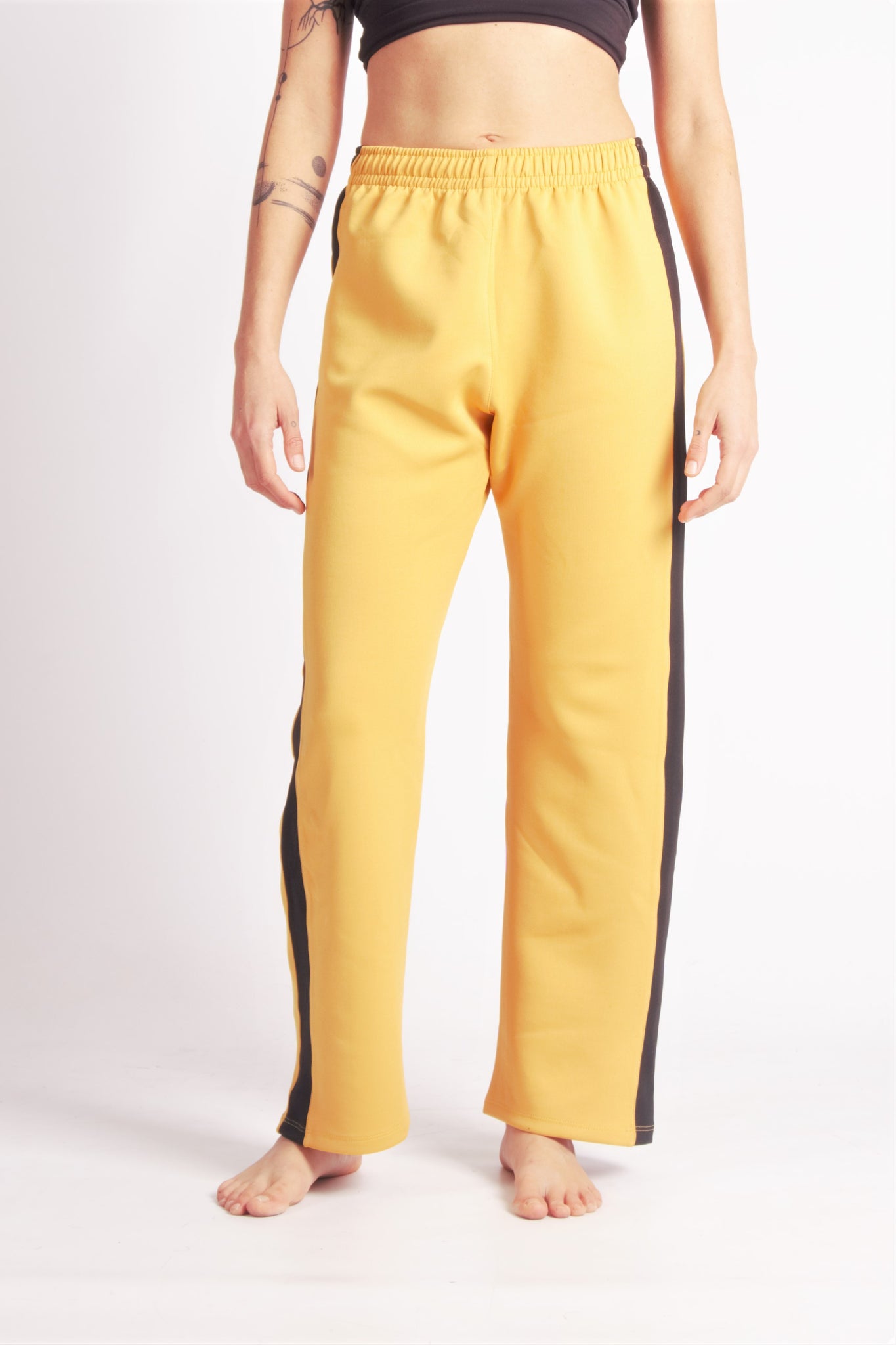 Flying Dance Pants es un pantalón de danza técnico unisex para entrenamiento de baile, danza contemporánea, acrobacia, yoga, artes marciales, pilates y cualquier disciplina vinculada al movimiento. Ideal para el trabajo de suelo, con un tejido resistente, deslizante y super absorbente. Color Mostaza y Negro.