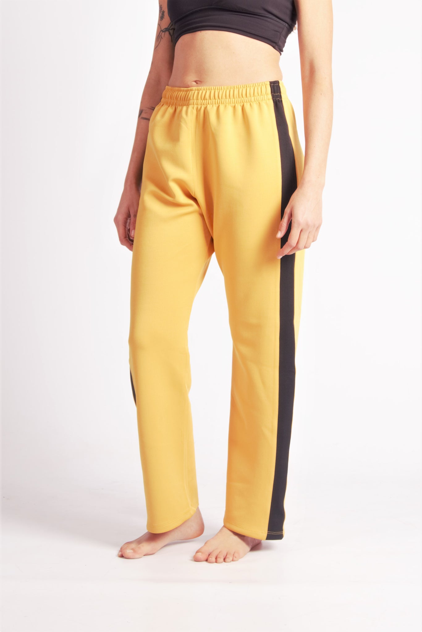 Flying Dance Pants es un pantalón de danza técnico unisex para entrenamiento de baile, danza contemporánea, acrobacia, yoga, artes marciales, pilates y cualquier disciplina vinculada al movimiento. Ideal para el trabajo de suelo, con un tejido resistente, deslizante y super absorbente. Color Mostaza y Negro.